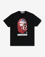 BLACK::A black Undefeated and Bape t-shirt on a white background.